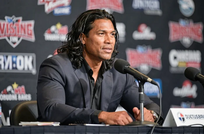 Superstar du catch en conférence de presse sportive, illustrant le gabarit physique et la prestance d'un champion de lutte professionnel